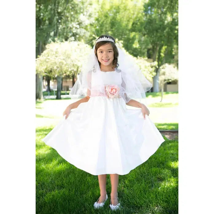 model wearing a white flower girl dress with a pink sash image 2