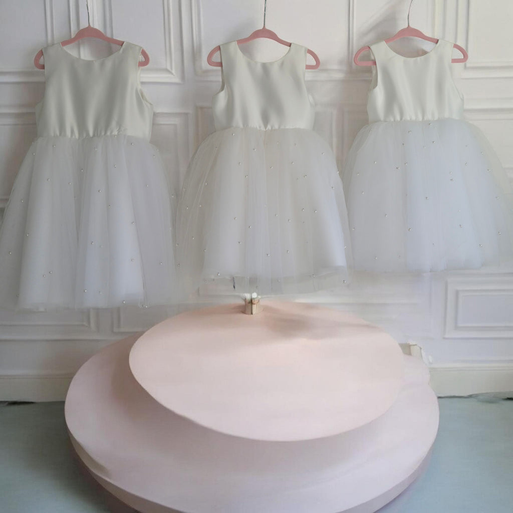 three Elegant white Flower Girl Dresses hanging on hooks image 4