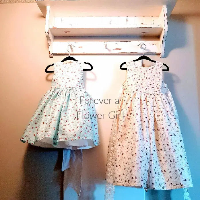 two Floral Cotton flower girl dresses hanging on a hook image 2