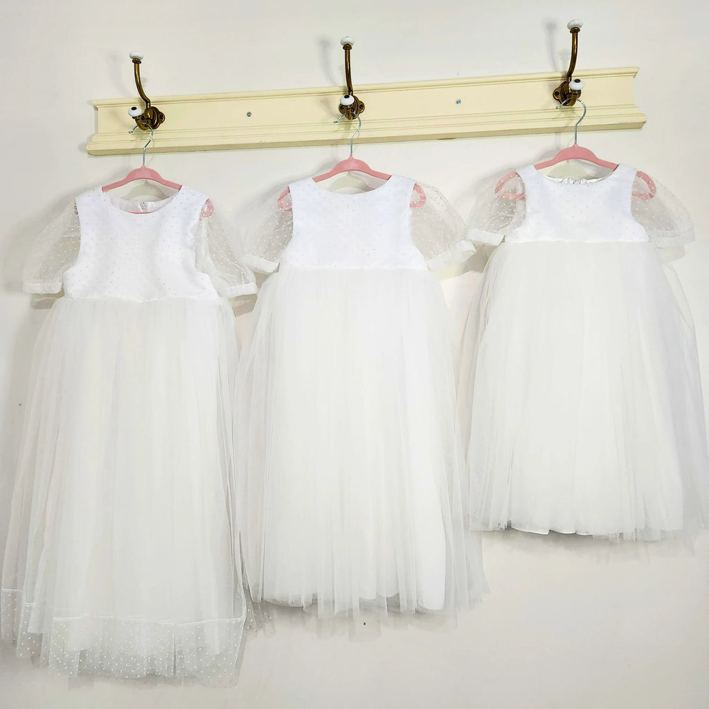 three White flower girl Dresses hanging on a hook image 3