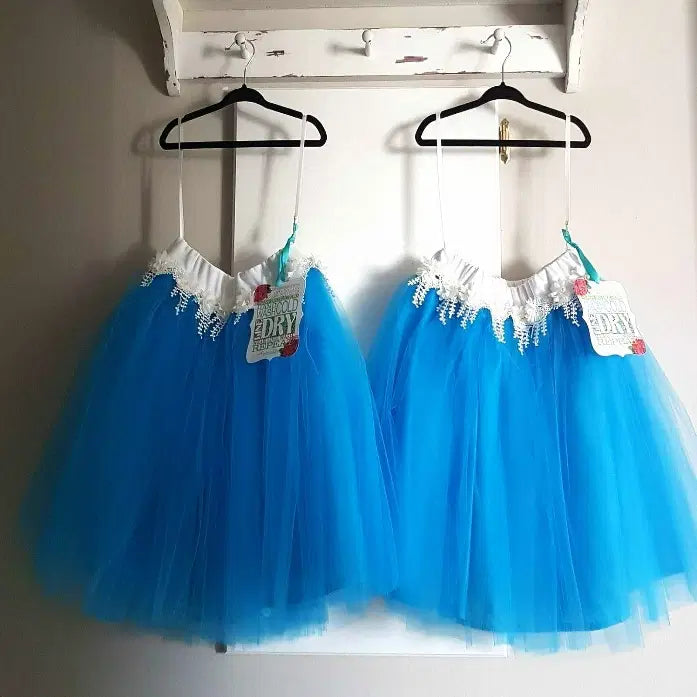 Two Turquoise Tutu Skirts For Girls hanging on hooks image 2