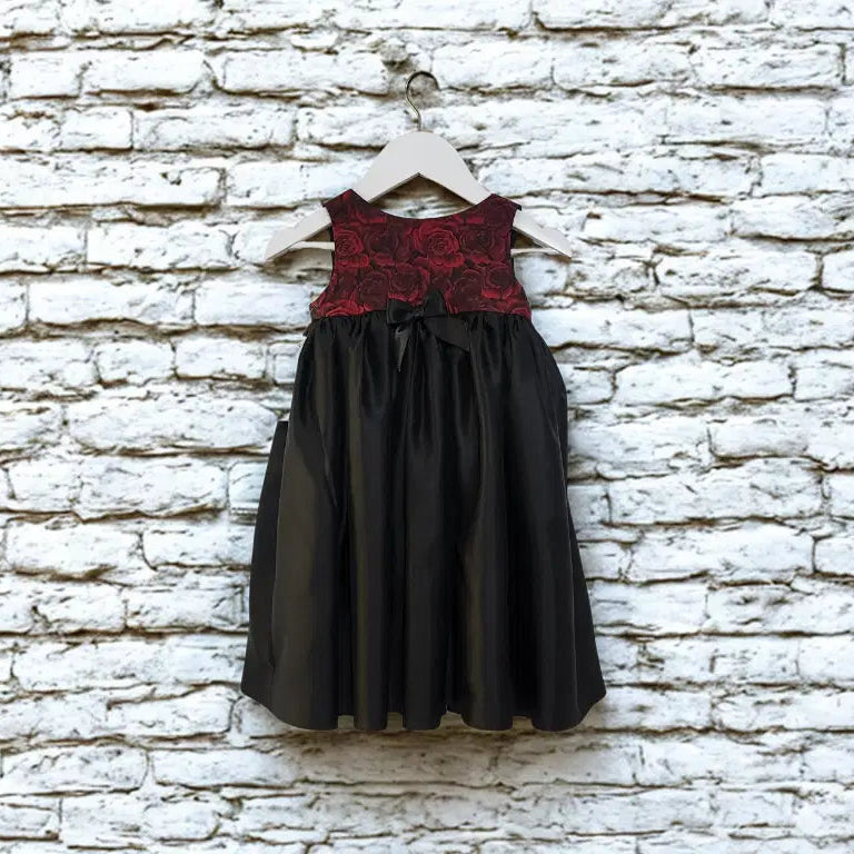 Girls Special Occasion red and black Dress hanging against a brick wall image 4