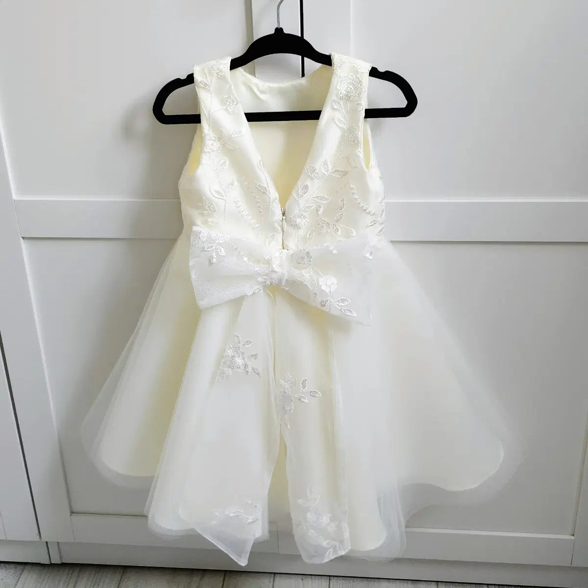 back view Classic Ivory Flower Girl Dress With Lace Bow hanging on a hook image 7