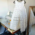purple Floral Cotton flower girl dress  hanging beside a sewing machine image 3