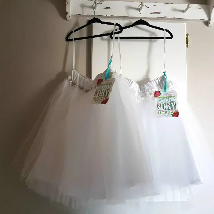 Girls White Tulle Skirts hanging on a hook image 2