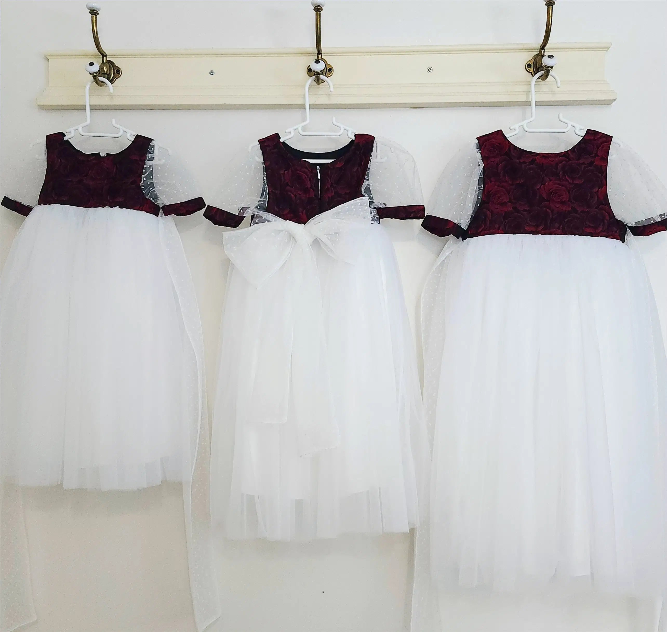 three Red and White Flower Girl Dresses hanging on a hook image 1